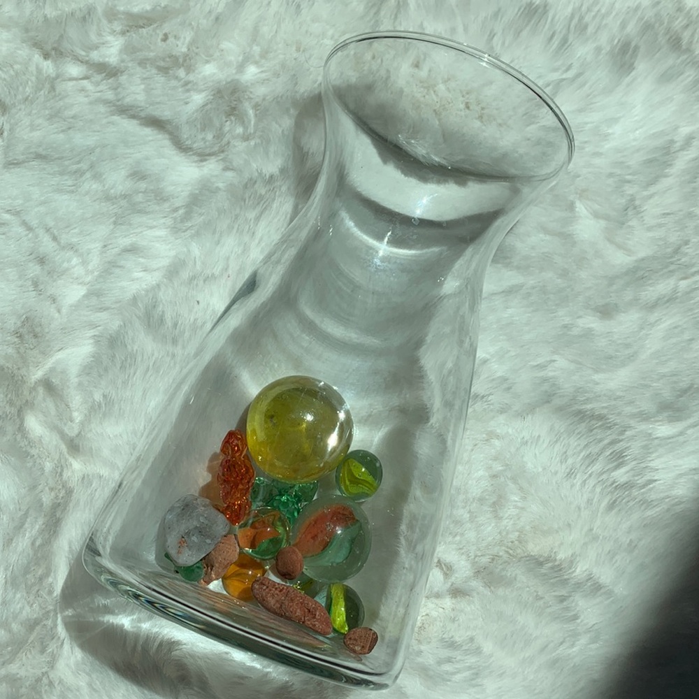 Short glass vase with marbles, rocks and other cute trinkets.